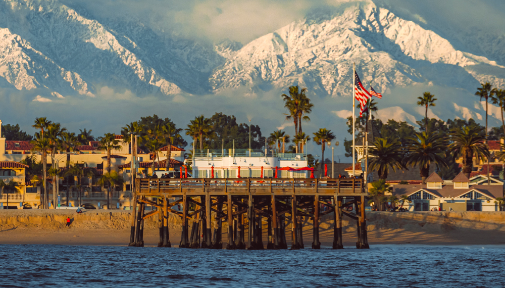 The Balboa Pier with snow on the mountains in the background
