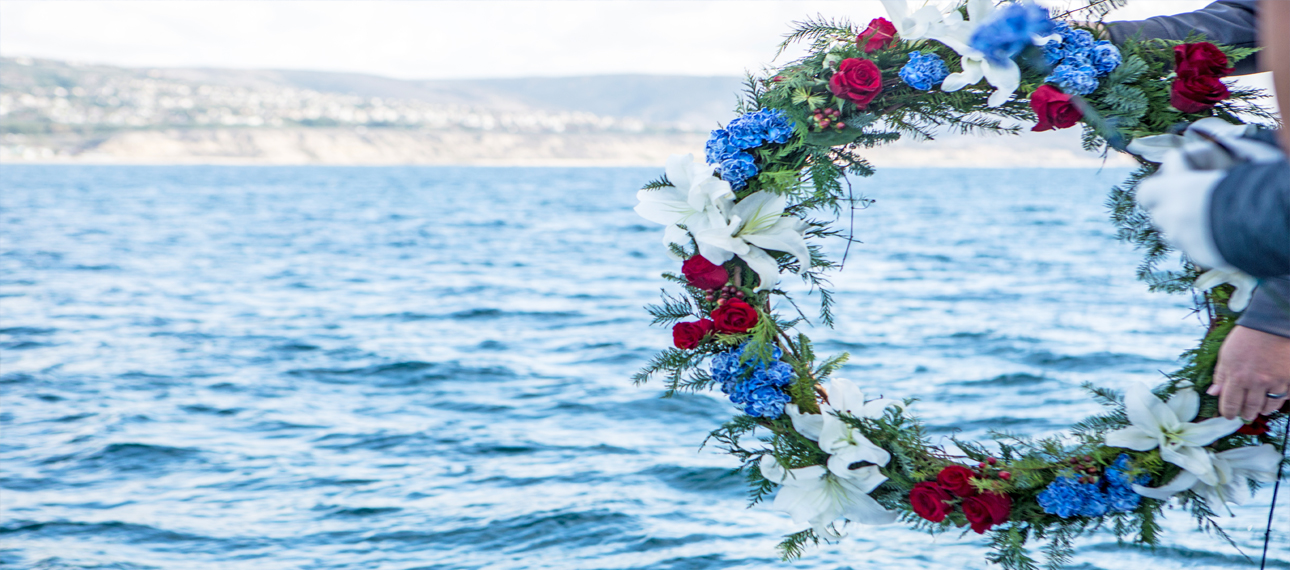 A floral wreath is lowered into the Pacific Ocean in honor of a loved one during a Burial At Sea ceremony.
